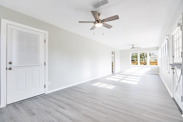 unfurnished living room with baseboards, ceiling fan, visible vents, and light wood-style floors