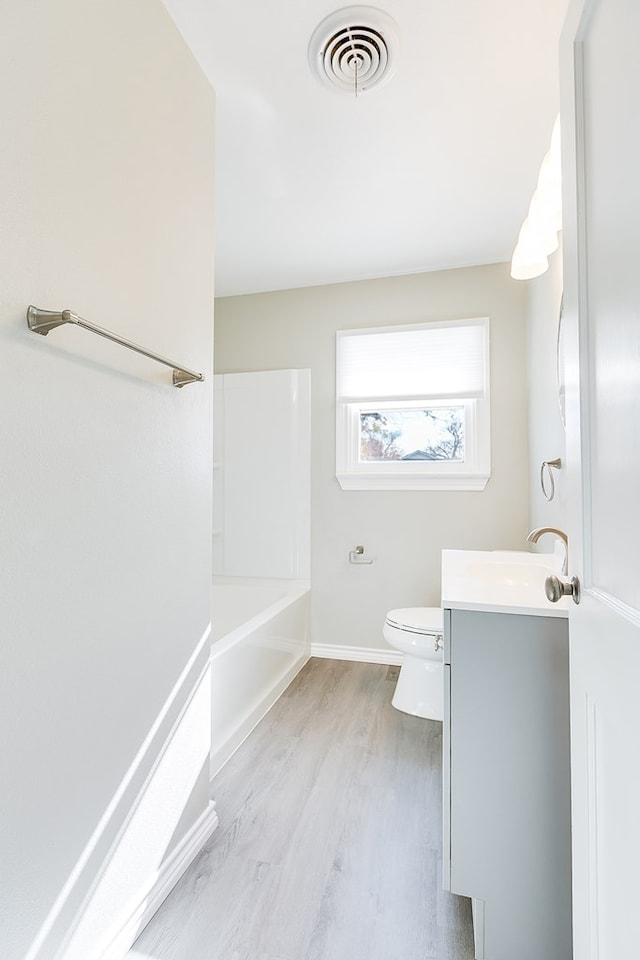 full bathroom featuring baseboards, visible vents, toilet, wood finished floors, and vanity