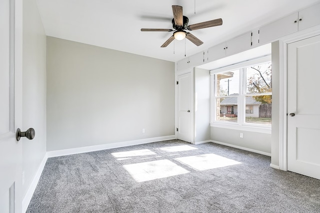 unfurnished bedroom featuring carpet floors, a ceiling fan, and baseboards