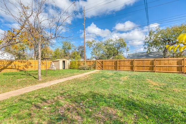 view of yard featuring an outbuilding, a storage shed, and a fenced backyard