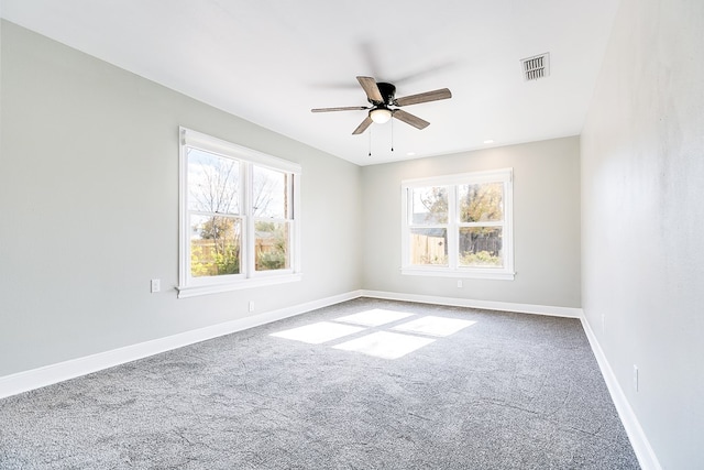 spare room with a healthy amount of sunlight, baseboards, visible vents, and ceiling fan