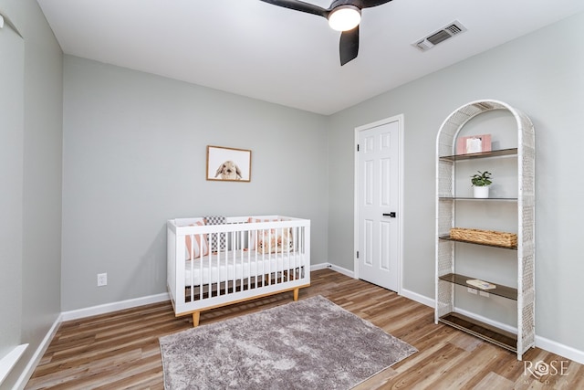 3421 Clearview Dr, San Angelo, TX 76904 - bedroom featuring wood finished floors, a ceiling fan, and a crib