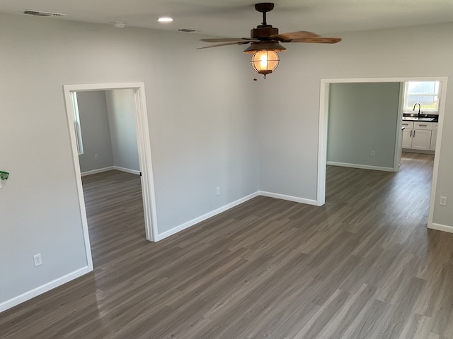 unfurnished room with dark wood-type flooring, ceiling fan, and sink