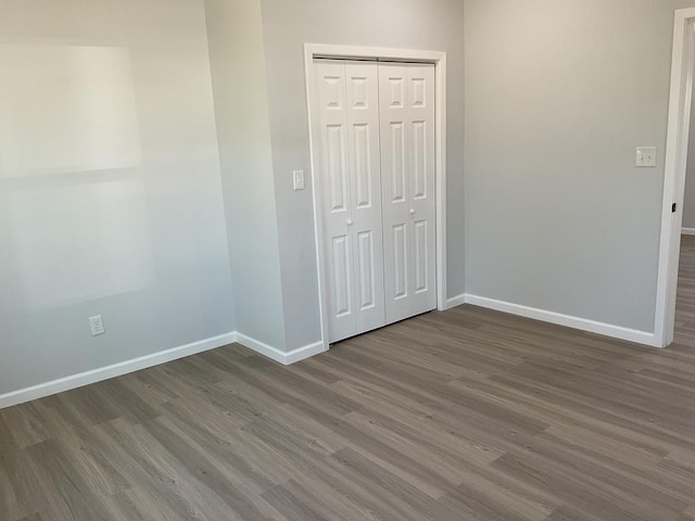 unfurnished bedroom with hardwood / wood-style floors and a closet