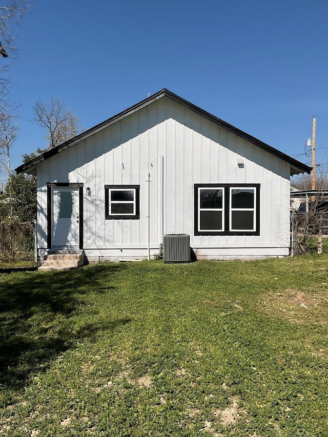 view of outbuilding with cooling unit and a lawn