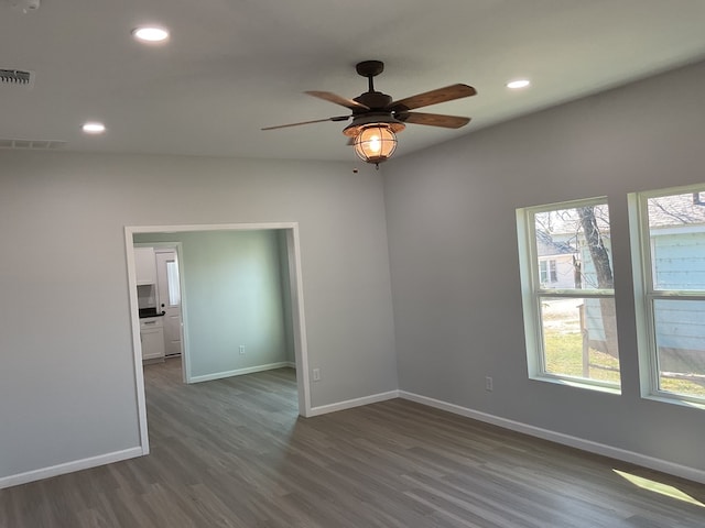 spare room with dark hardwood / wood-style floors and ceiling fan