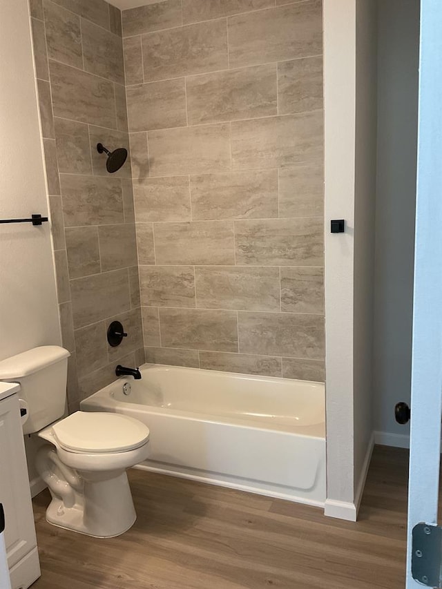 full bathroom with vanity, tiled shower / bath combo, wood-type flooring, and toilet