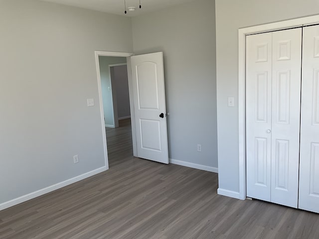 unfurnished bedroom featuring dark hardwood / wood-style floors and a closet