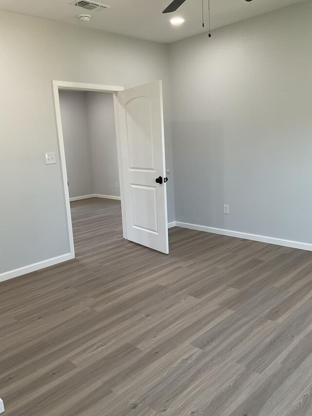 spare room featuring ceiling fan and dark hardwood / wood-style flooring