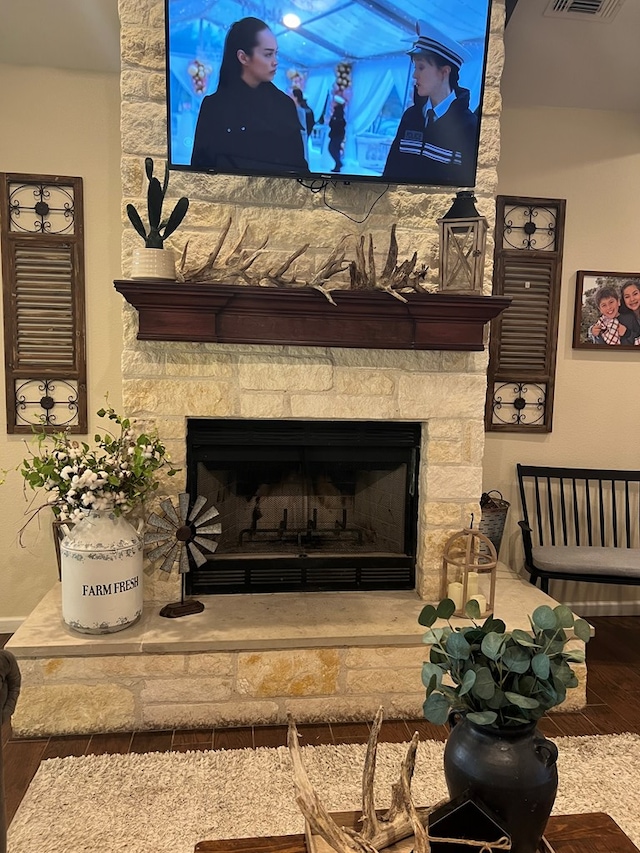 room details with a stone fireplace and hardwood / wood-style floors