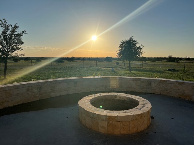 exterior space featuring a patio, a rural view, and a fire pit