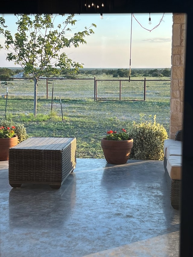 patio terrace at dusk featuring a rural view