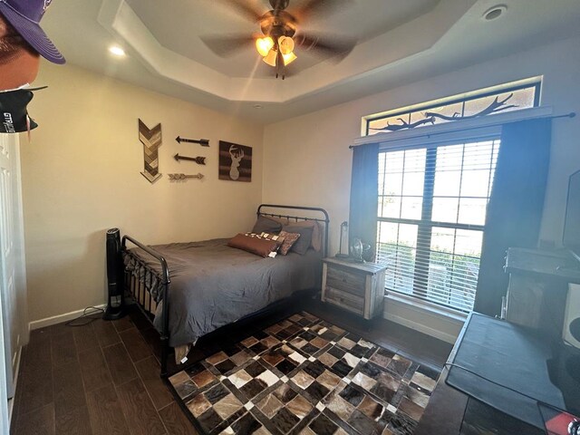 bedroom with ceiling fan and a raised ceiling