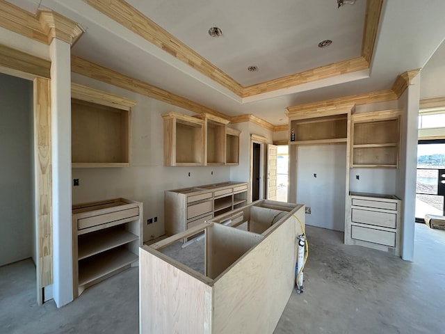 kitchen featuring ornamental molding, concrete flooring, a raised ceiling, and light brown cabinetry