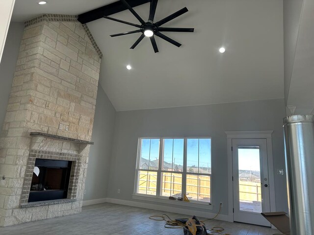 unfurnished living room with beamed ceiling, a fireplace, and high vaulted ceiling