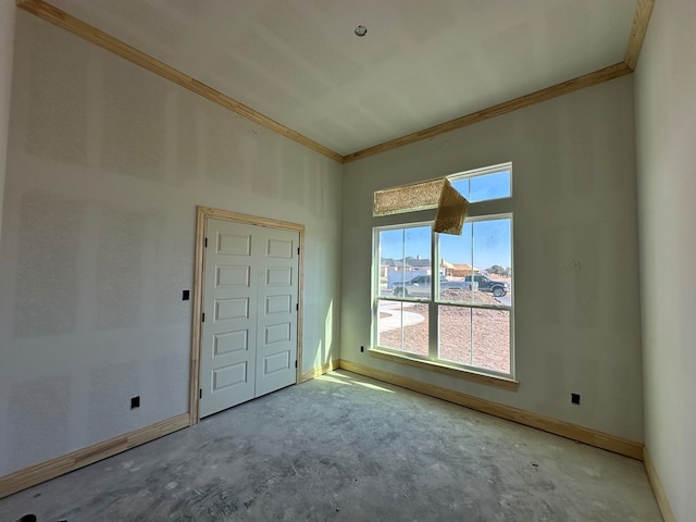 unfurnished room with a high ceiling and crown molding