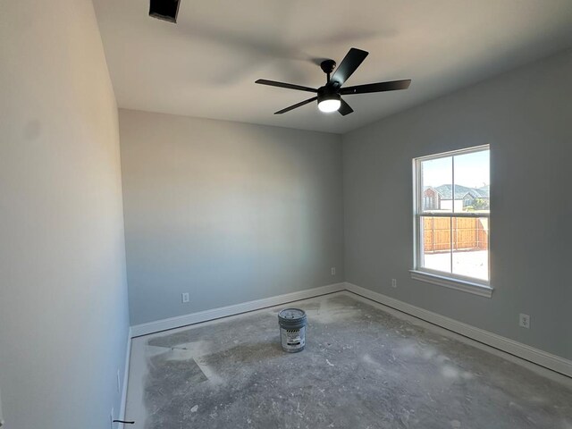 bathroom with tiled shower and concrete floors