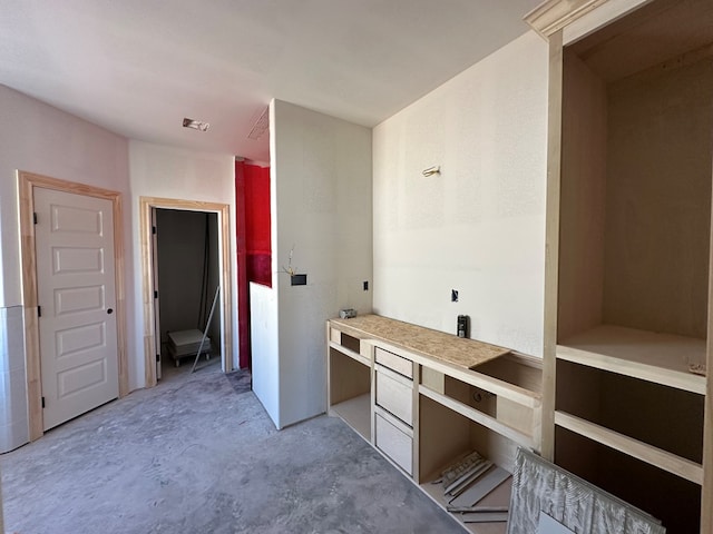 interior space with concrete flooring and built in desk