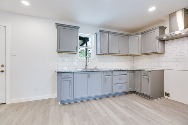 2624 Dallas St, San Angelo, TX 76903 - kitchen with wall chimney range hood, a sink, gray cabinets, light wood finished floors, and recessed lighting