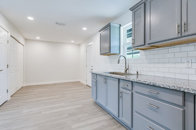 2624 Dallas St, San Angelo, TX 76903 - kitchen featuring a sink, backsplash, light wood-type flooring, baseboards, and recessed lighting