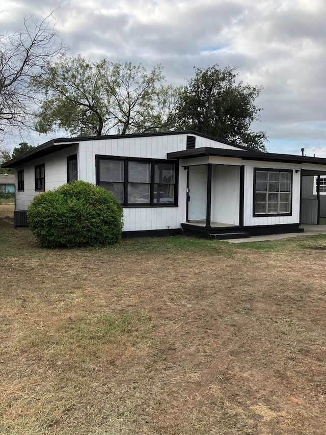 view of front of home with central air condition unit and a front lawn