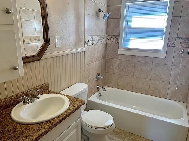 full bathroom with a wainscoted wall, toilet, shower / bath combination, and vanity