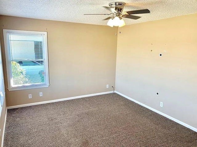 carpeted spare room with ceiling fan, baseboards, and a textured ceiling