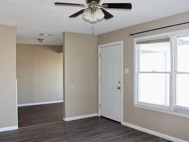 entryway featuring dark wood-style floors, visible vents, baseboards, ceiling fan, and a textured ceiling