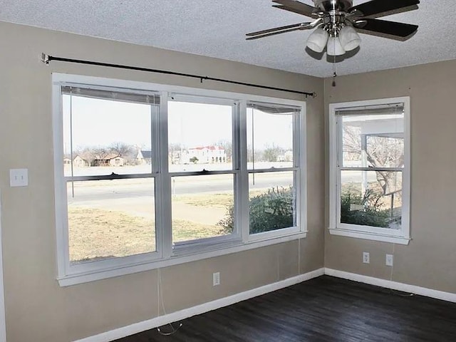 unfurnished room featuring baseboards, a textured ceiling, ceiling fan, and dark wood-style flooring