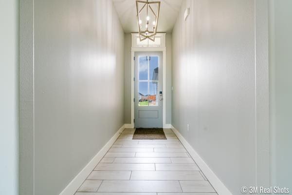 doorway to outside with a chandelier