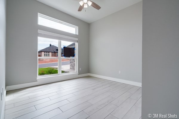 empty room with ceiling fan and light wood-type flooring