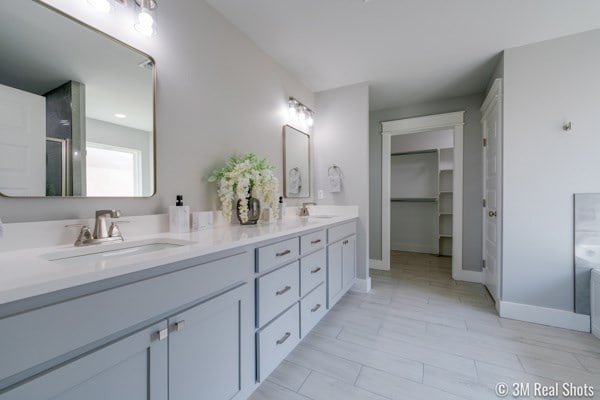 bathroom featuring a shower with door and vanity