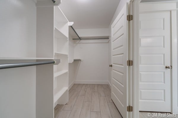 walk in closet with light hardwood / wood-style flooring