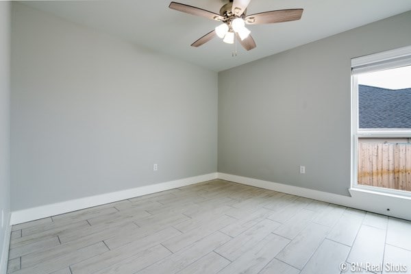 spare room featuring ceiling fan and plenty of natural light