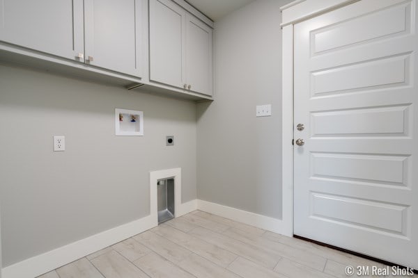 laundry area featuring electric dryer hookup, washer hookup, and cabinets