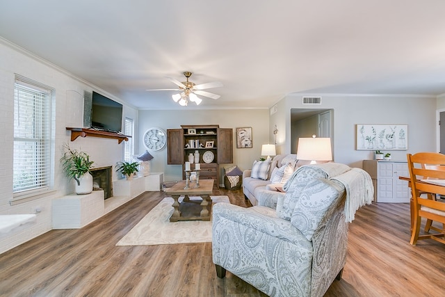 2709 Janie Ln, San Angelo, TX 76905 - living area featuring wood finished floors, ornamental molding, a fireplace, and a ceiling fan