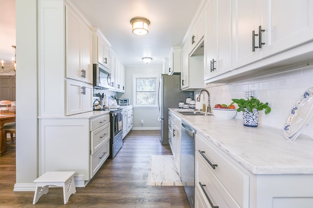 2709 Janie Ln, San Angelo, TX 76905 - kitchen with appliances with stainless steel finishes, a sink, dark wood-style flooring, backsplash, and white cabinets