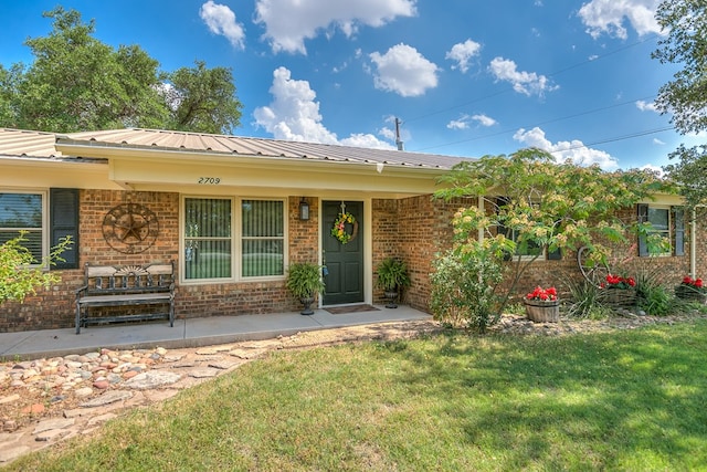 2709 Janie Ln, San Angelo, TX 76905 - ranch-style house with brick siding, a front lawn, and metal roof