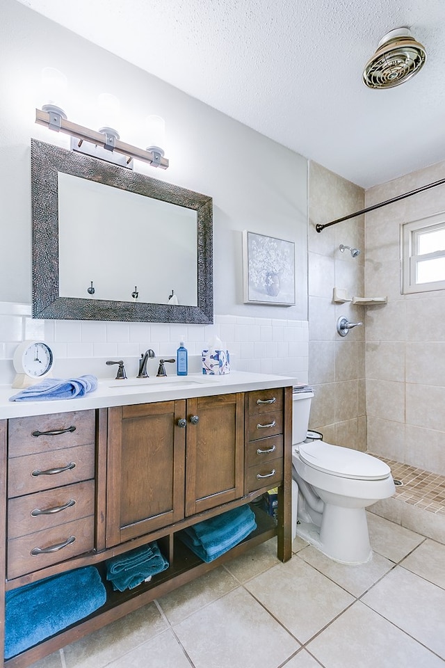 2709 Janie Ln, San Angelo, TX 76905 - full bathroom with toilet, vanity, tiled shower, tile patterned floors, and tile walls