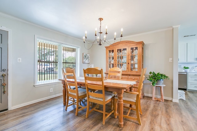 2709 Janie Ln, San Angelo, TX 76905 - dining room with a chandelier, crown molding, light wood-style floors, and baseboards