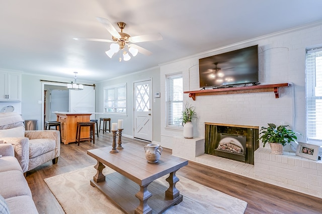 2709 Janie Ln, San Angelo, TX 76905 - living area with crown molding, light wood finished floors, a ceiling fan, and a fireplace