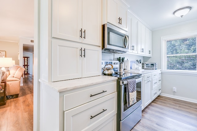2709 Janie Ln, San Angelo, TX 76905 - kitchen featuring appliances with stainless steel finishes, light wood-style floors, white cabinets, baseboards, and light stone countertops