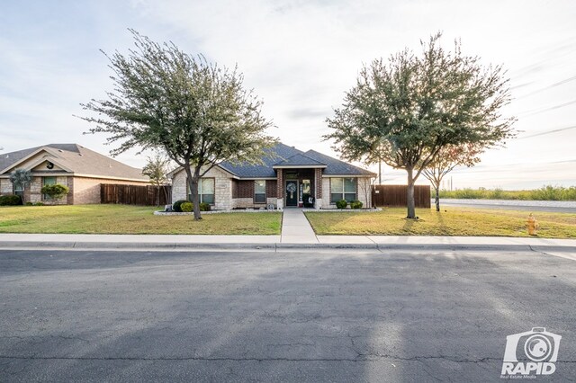 single story home featuring a front lawn