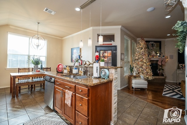 kitchen featuring hanging light fixtures, crown molding, light stone countertops, and sink