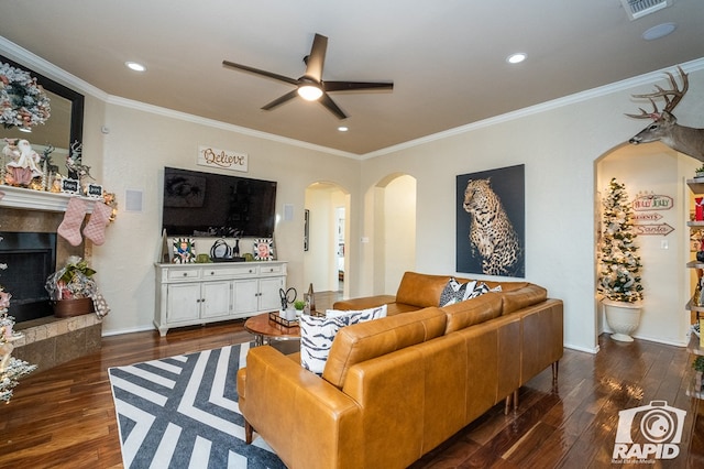 living room with dark hardwood / wood-style flooring, crown molding, and ceiling fan