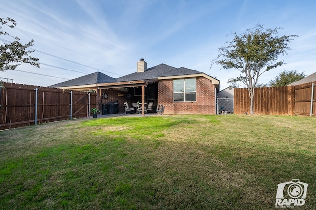 rear view of property featuring a yard and a patio area