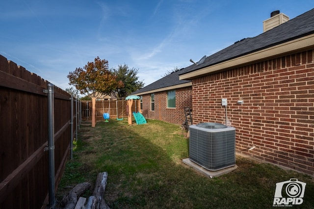 view of yard featuring a playground and central air condition unit