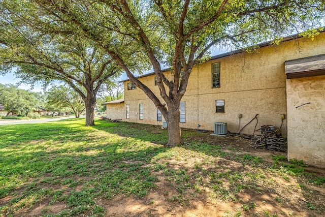 view of side of property with cooling unit and a yard