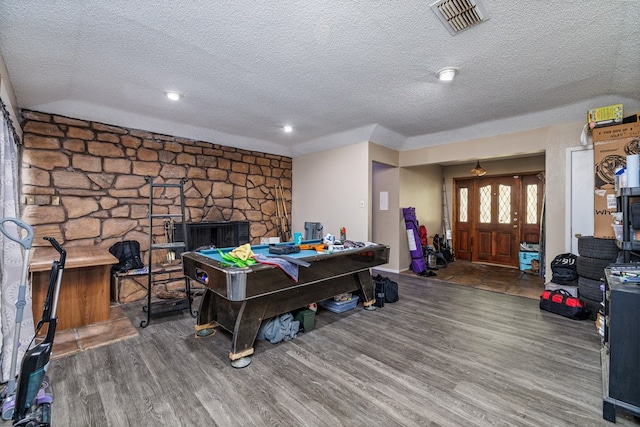 game room featuring wood-type flooring, a fireplace, and a textured ceiling