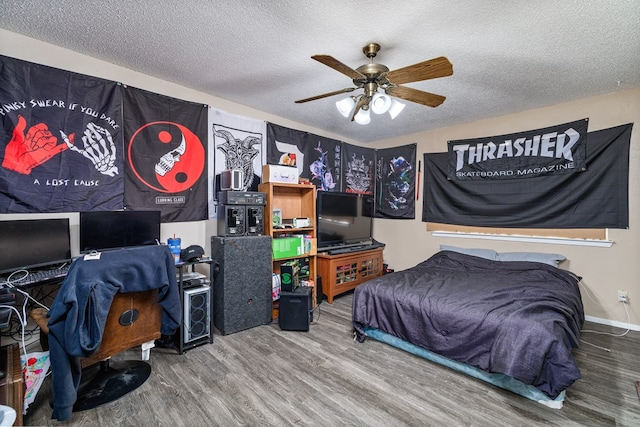 bedroom with ceiling fan, wood-type flooring, and a textured ceiling